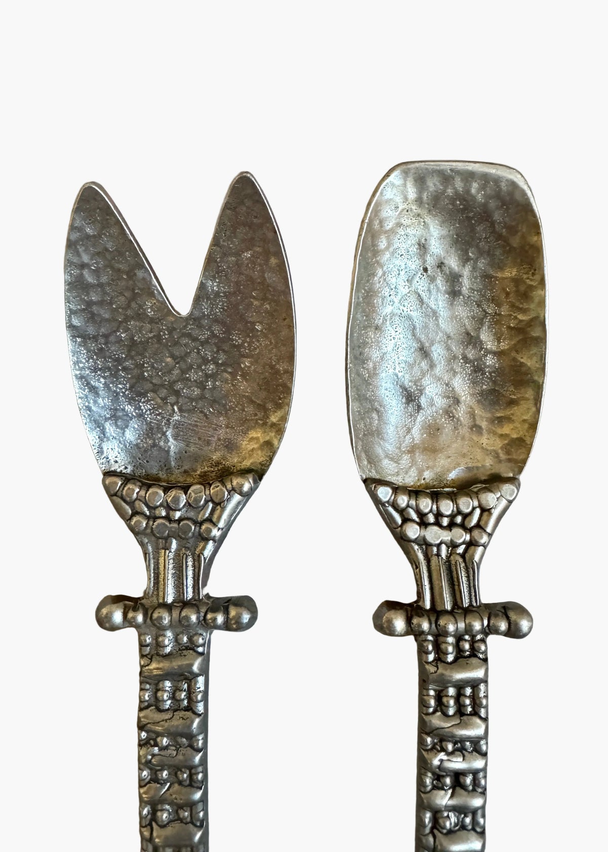Vintage pewter salad serving set with decorative handles, including fork and spoon, styled on a neutral background