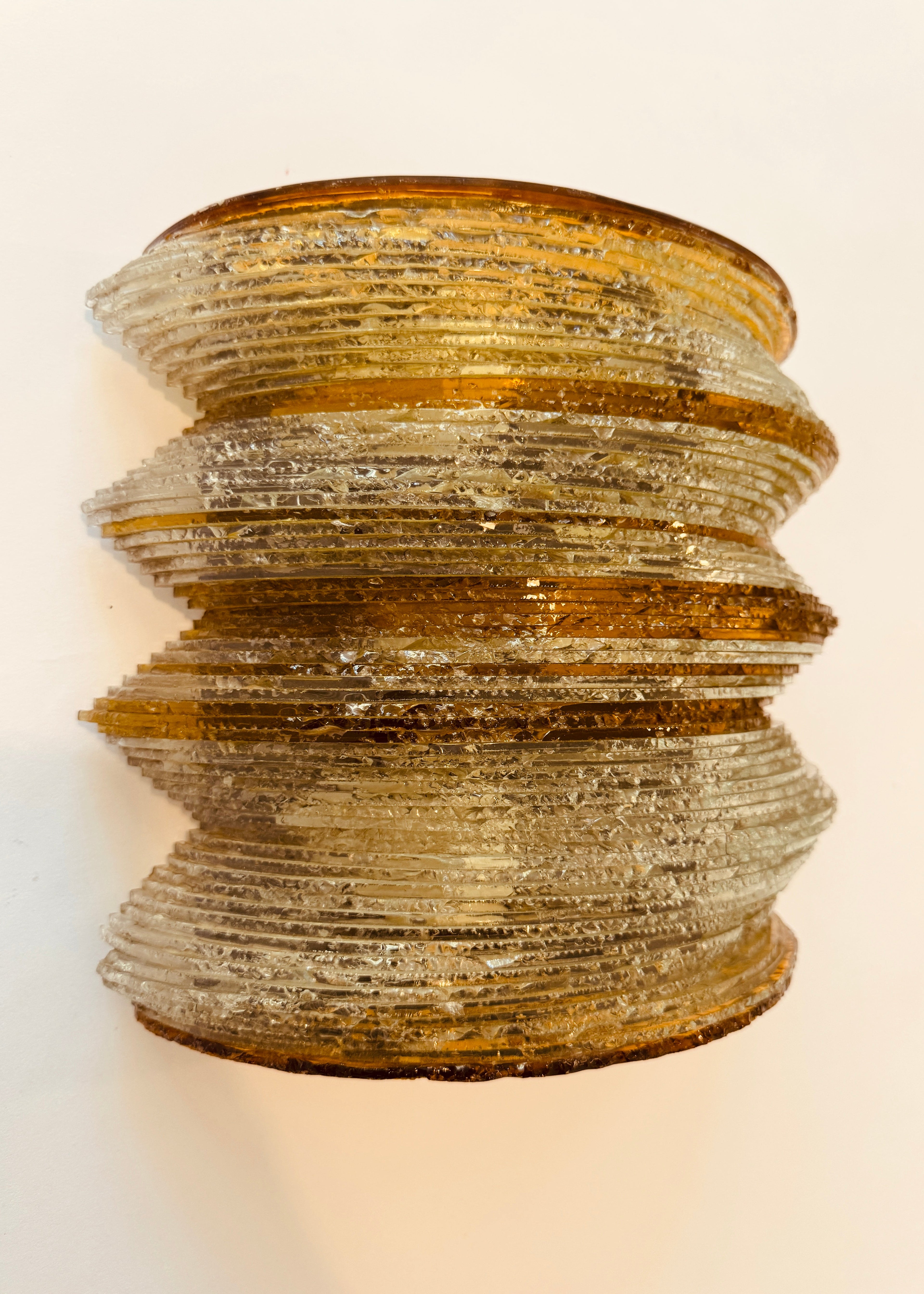 Decorative wall sconce with a textured design on a light background