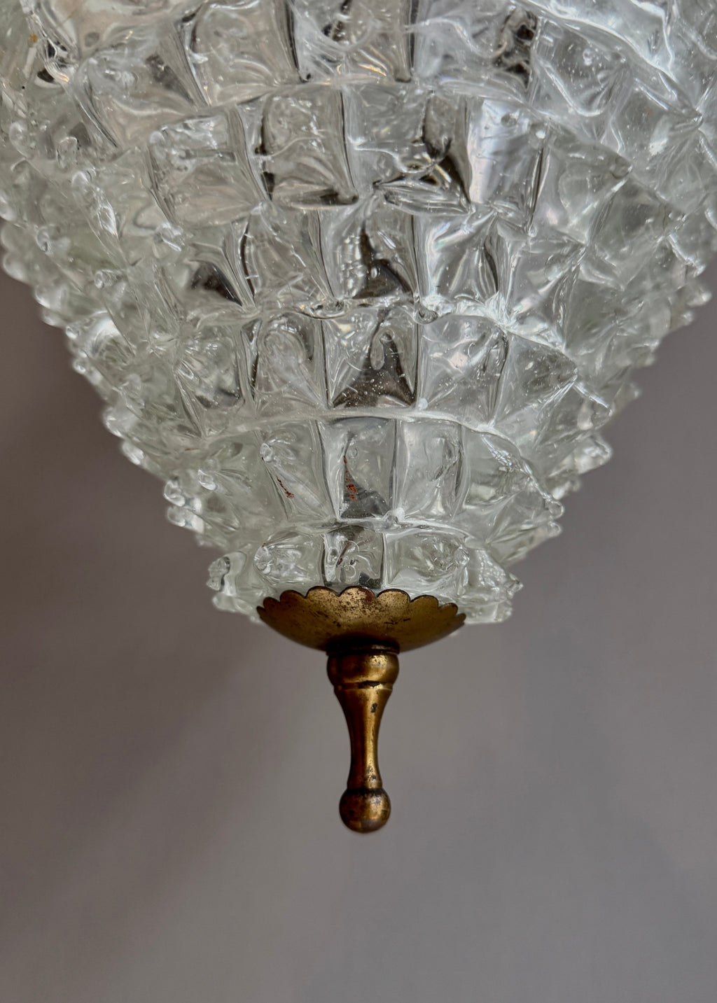 Close-up of a vintage-style chandelier with textured glass shade and gold fixture.