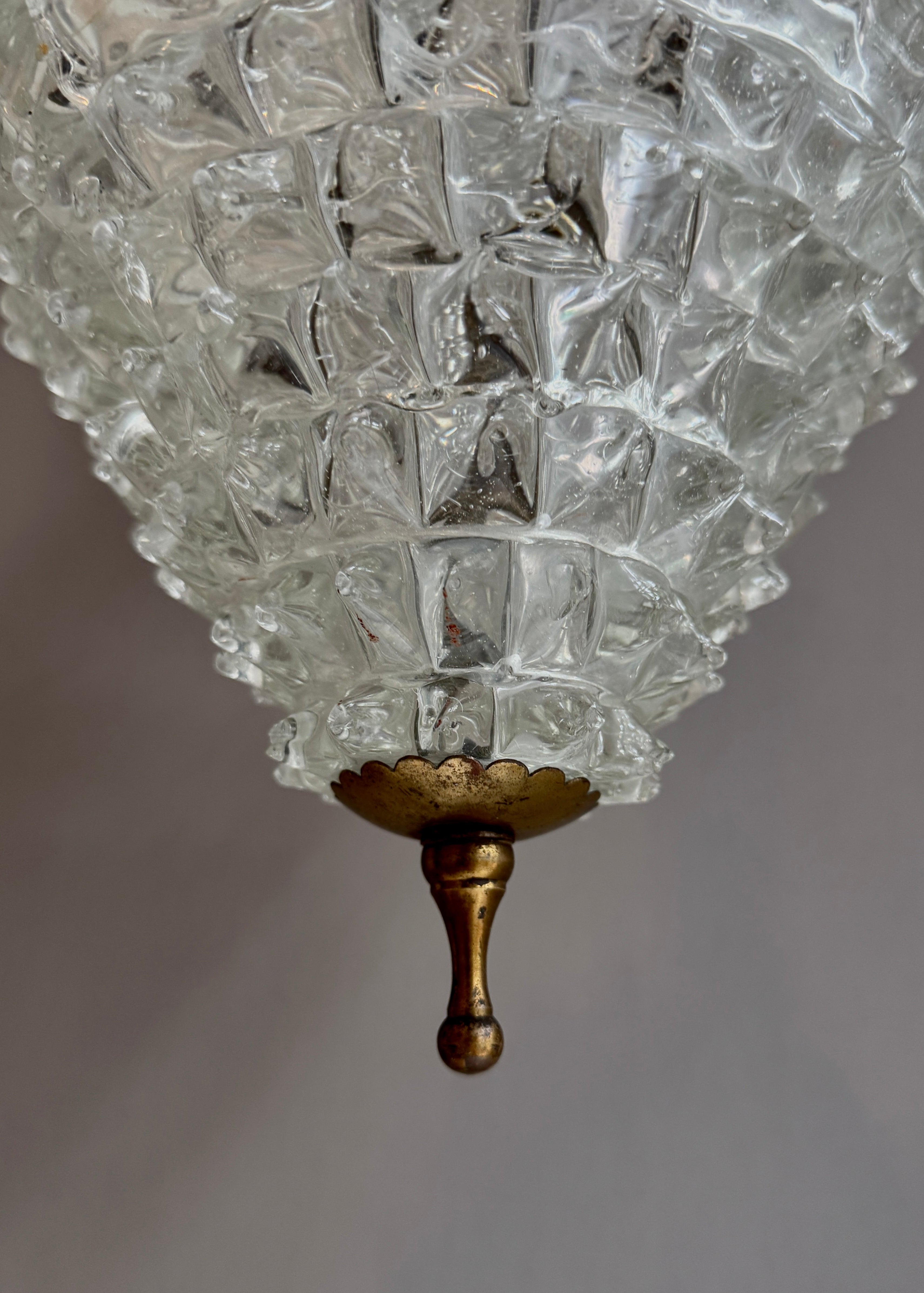 Close-up of a vintage-style chandelier with textured glass shade and gold fixture.