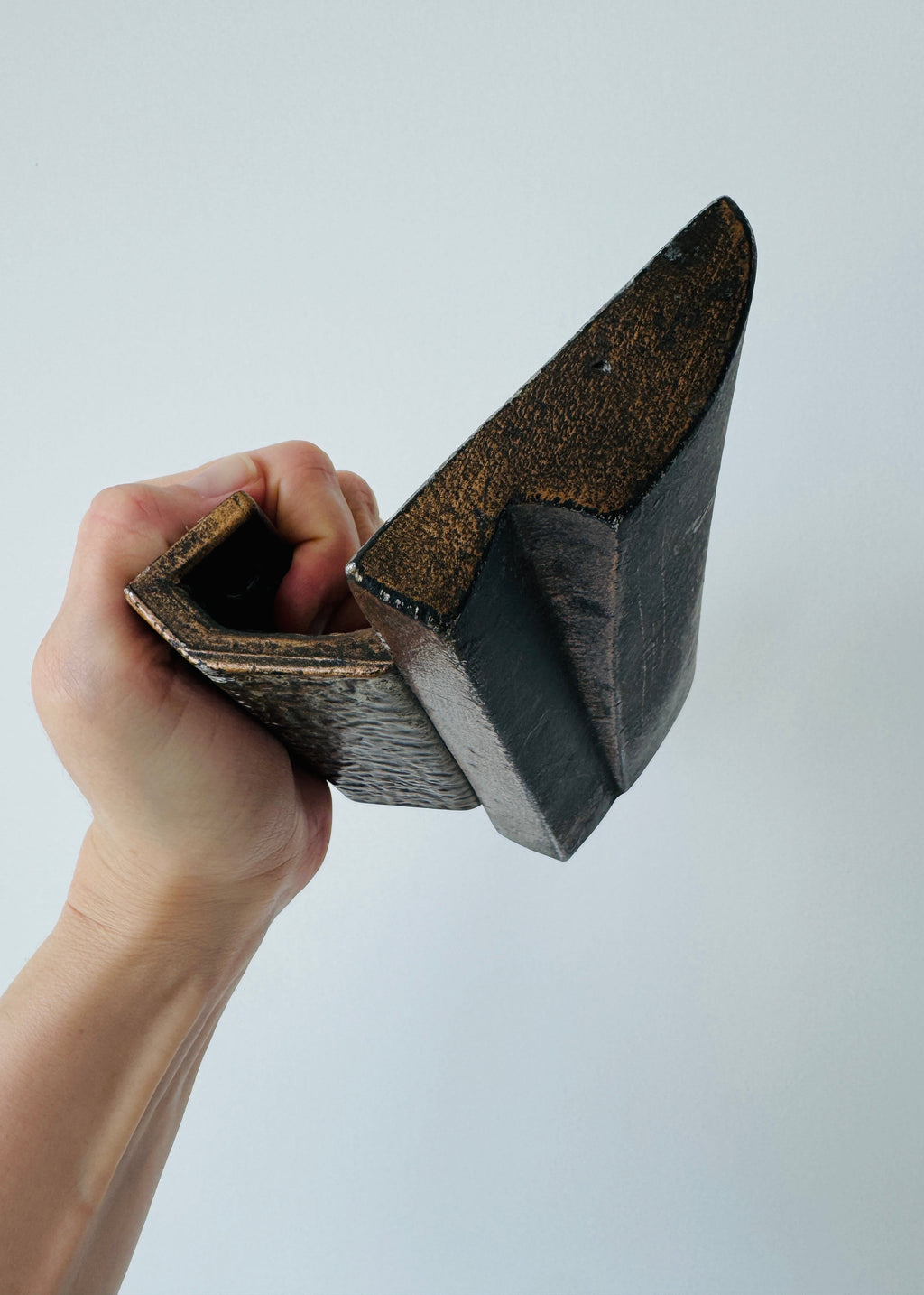 Vintage Brutalist sculptural door handle in dark patinated metal with angular folded grip and textured rectangular mounting plate.