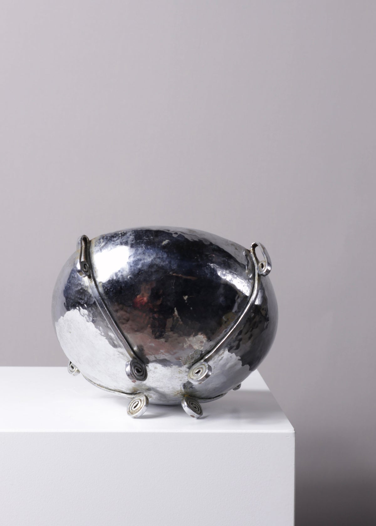 Close-up of the rim and hammered silver-plated surface of the antique Arts and Crafts bowl.