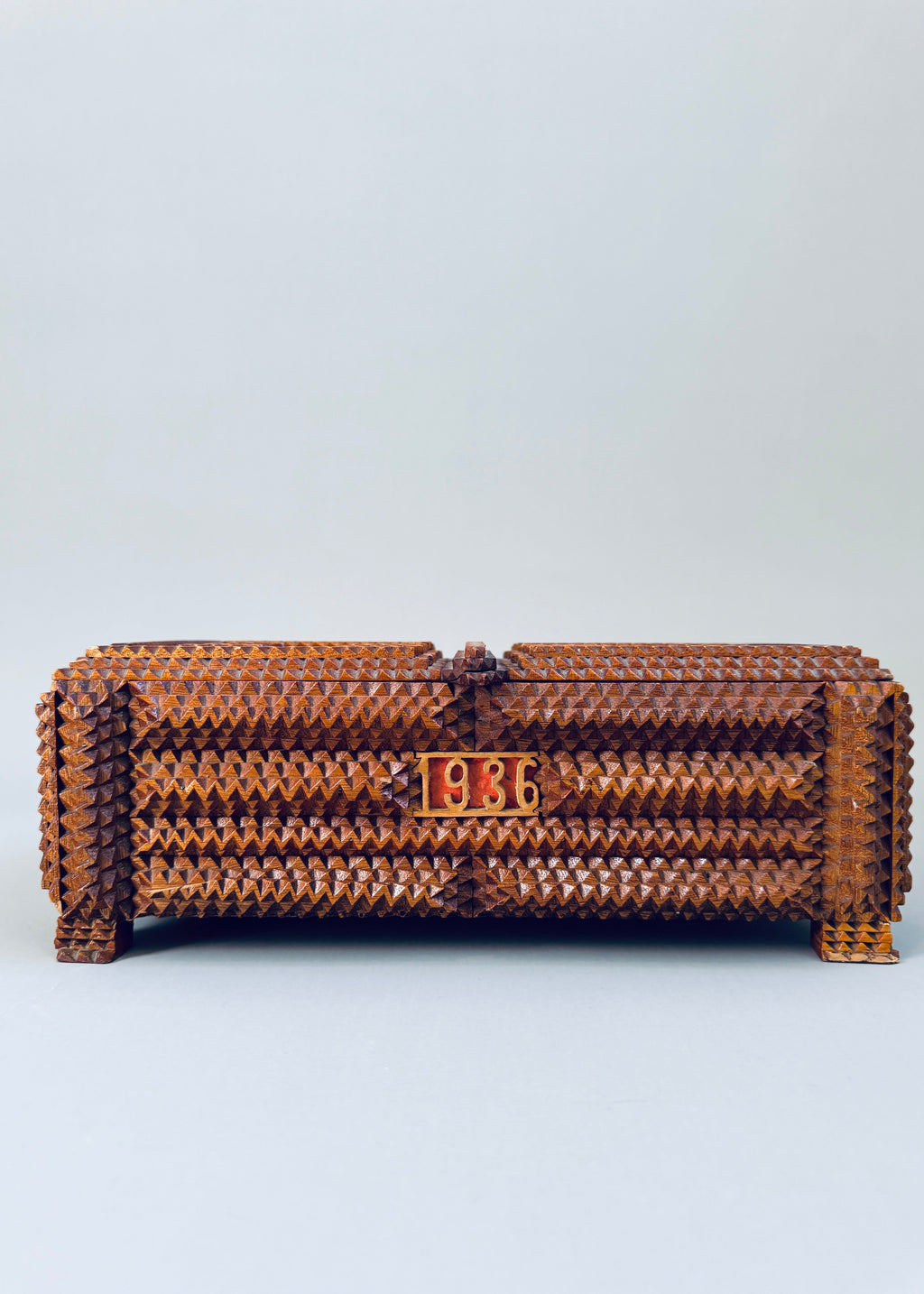 Antique 1936 tramp art wooden box with chip carved geometric pattern and stacked pedestal feet