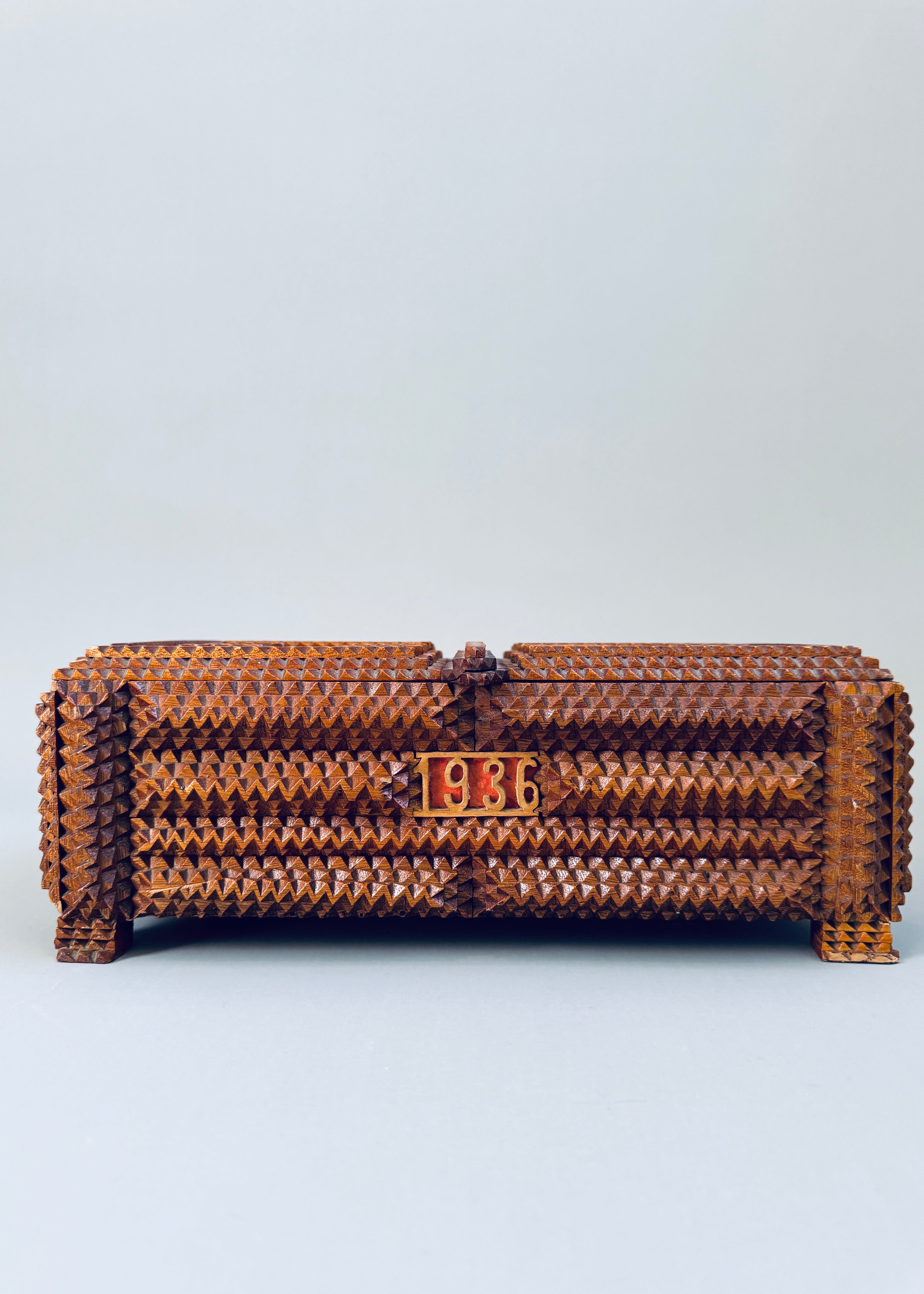 Antique 1936 tramp art wooden box with chip carved geometric pattern and stacked pedestal feet