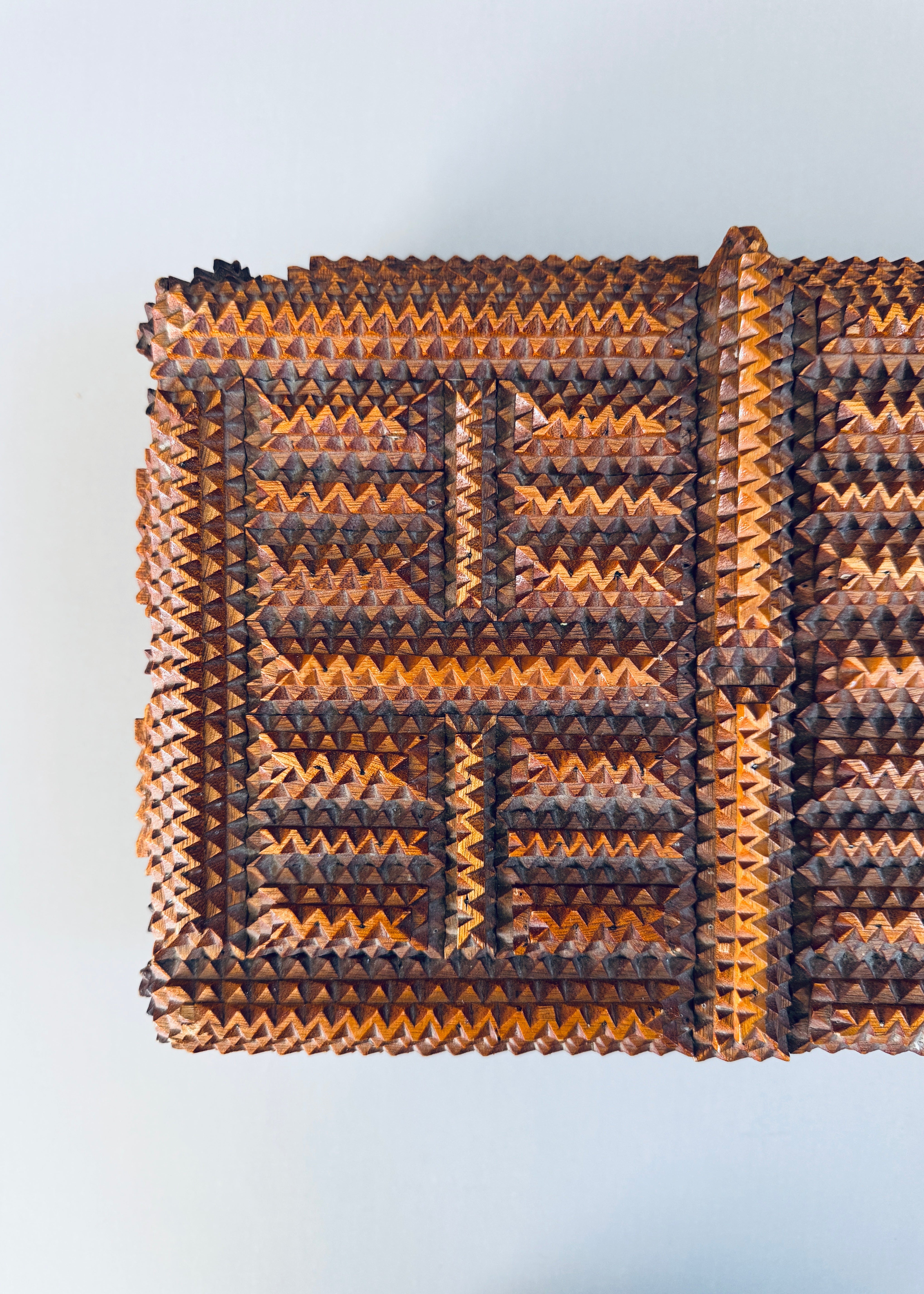 Antique 1936 tramp art wooden box with chip carved geometric pattern and stacked pedestal feet