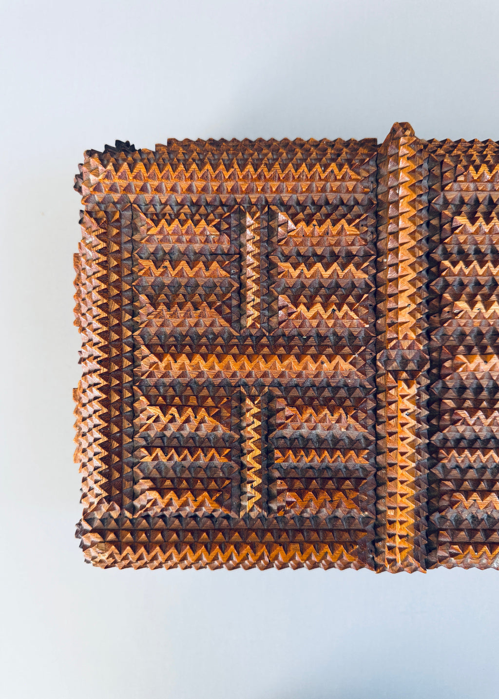 Antique 1936 tramp art wooden box with chip carved geometric pattern and stacked pedestal feet