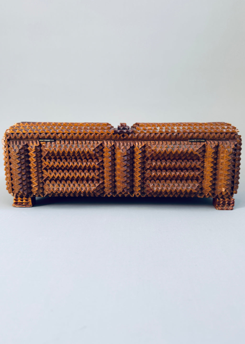 Antique 1936 tramp art wooden box with chip carved geometric pattern and stacked pedestal feet