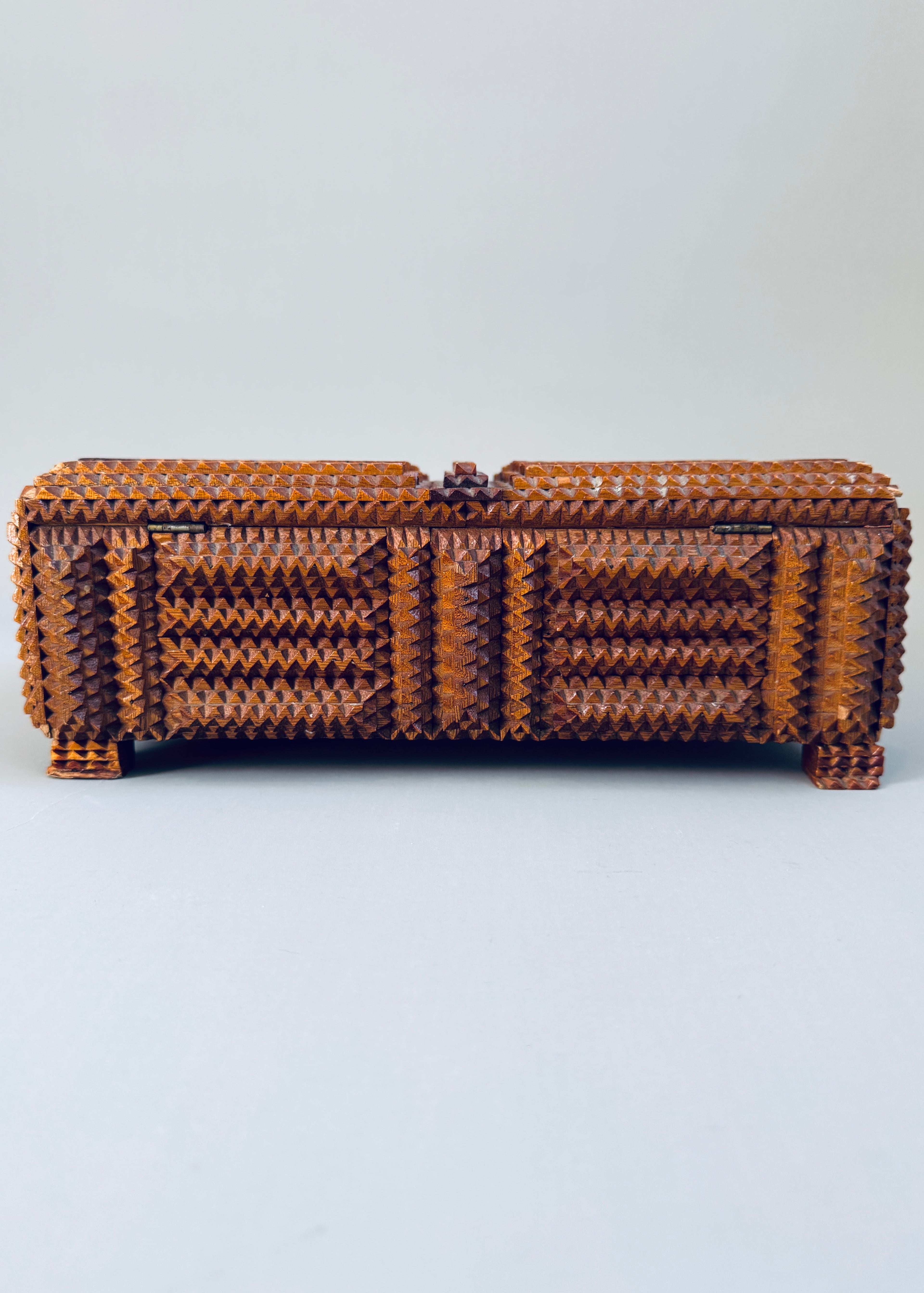 Antique 1936 tramp art wooden box with chip carved geometric pattern and stacked pedestal feet