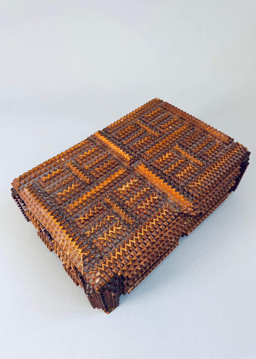 Antique 1936 tramp art wooden box with chip carved geometric pattern and stacked pedestal feet