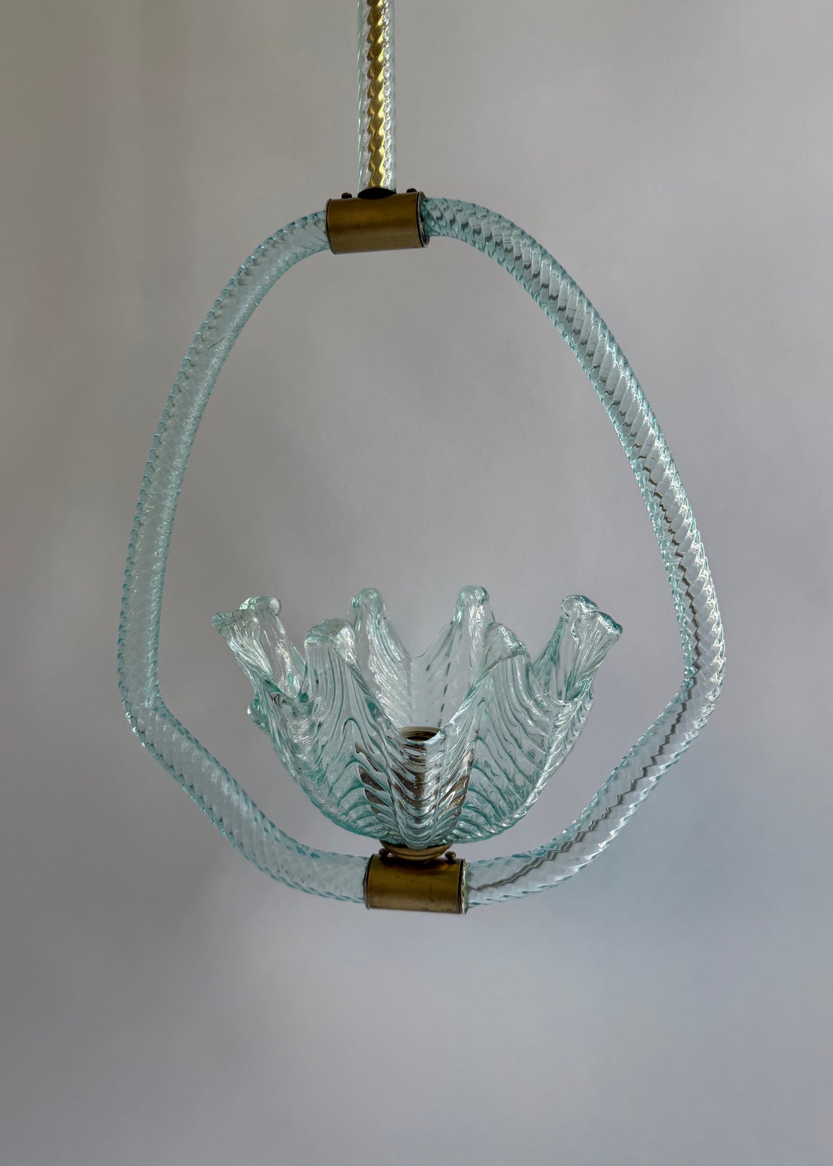 Front detail of the folded aqua glass shade framed by twisted clear glass and brass mounts.