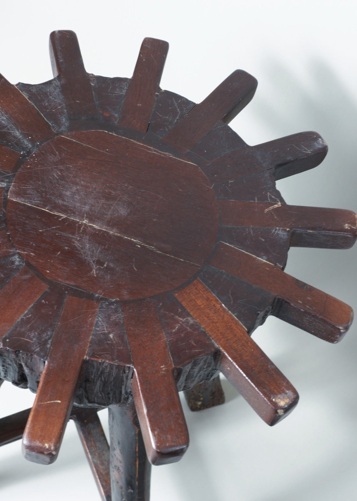 close up details of Wooden sunburst brutalist stool on a white background