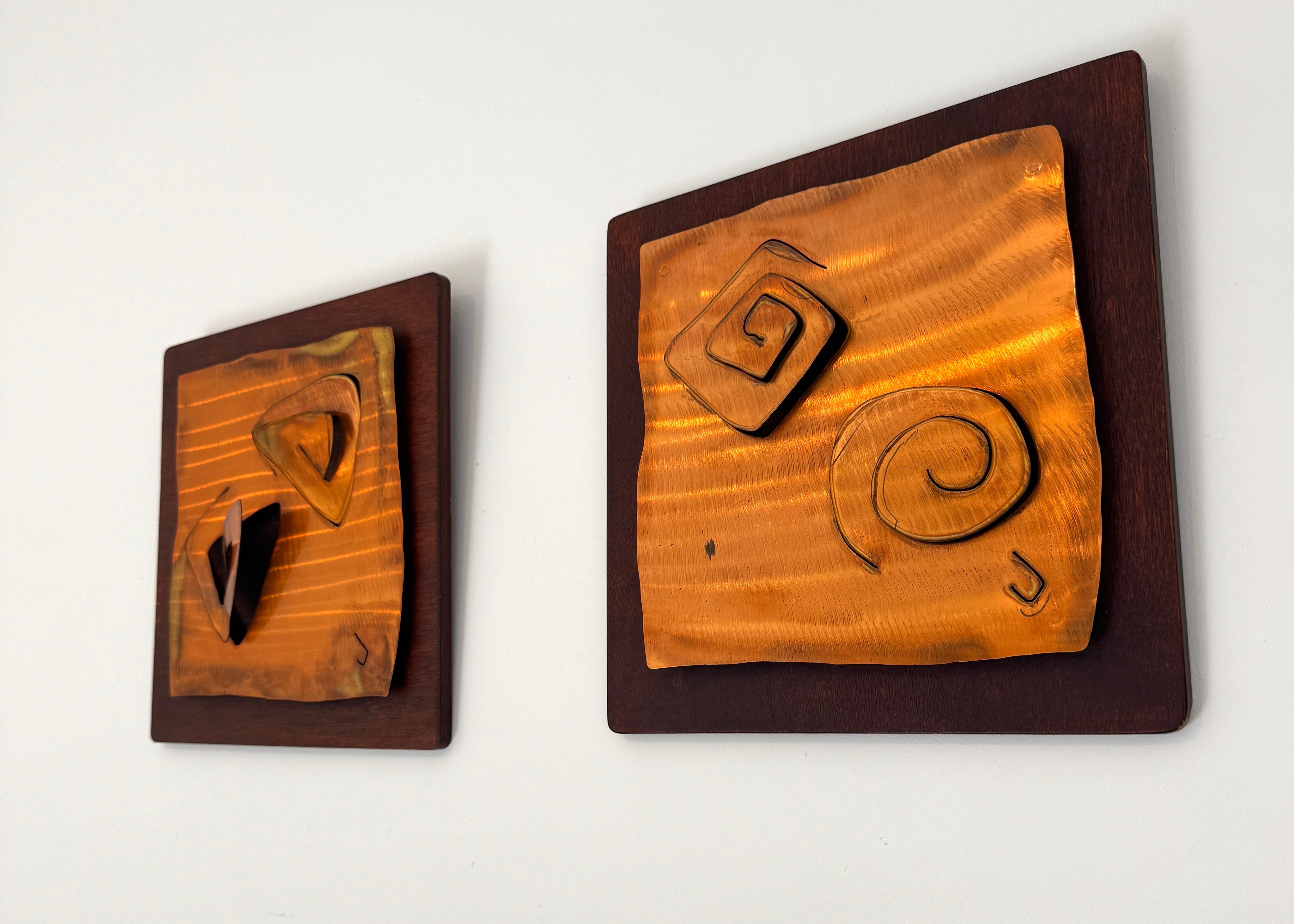 Pair of vintage hand-carved wooden wall panels with abstract organic shapes mounted on darker timber boards