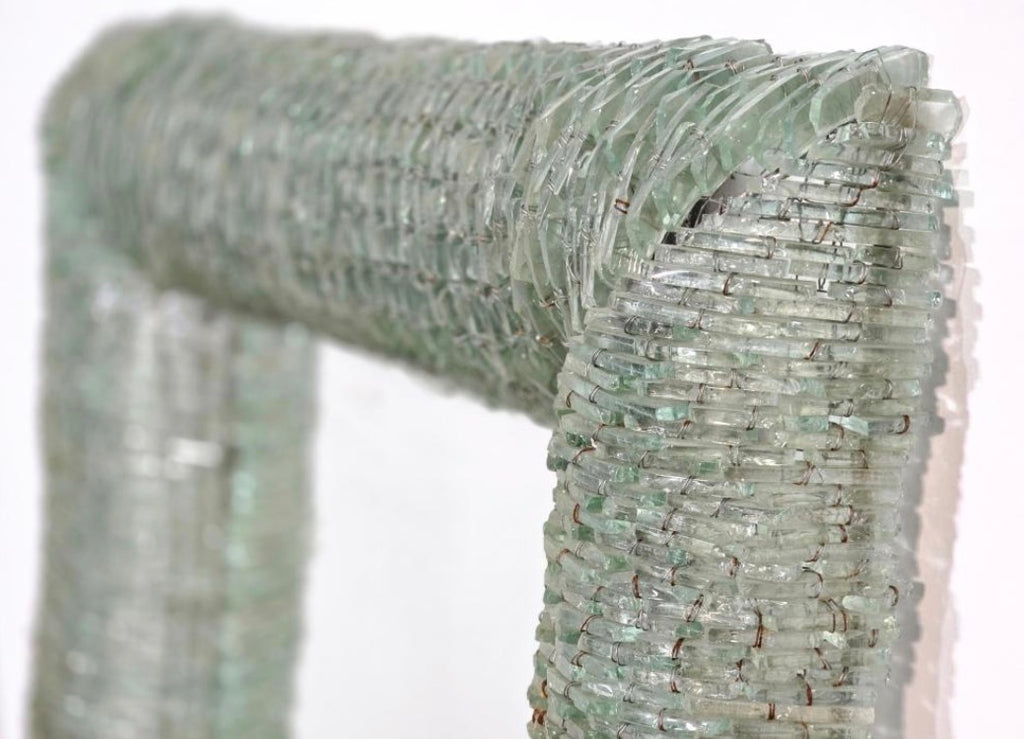 close-up detail of hand wired murano glass tiles forming sculptural mirror frame