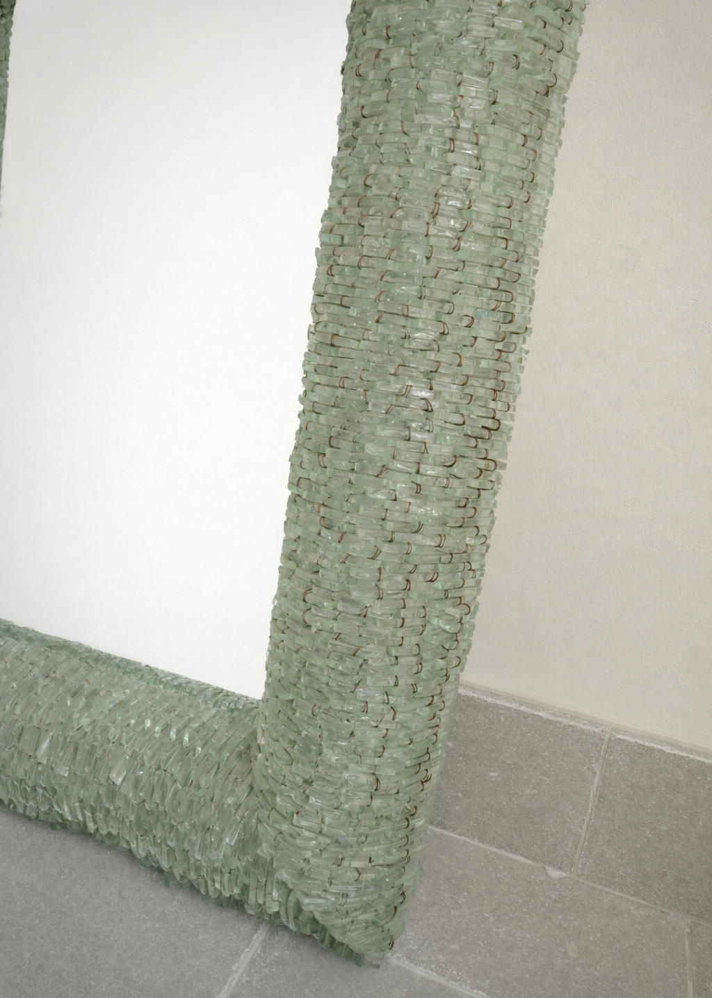 close up detail of a vintage italian murano segmented glass  tile mirror with textured green glass frame