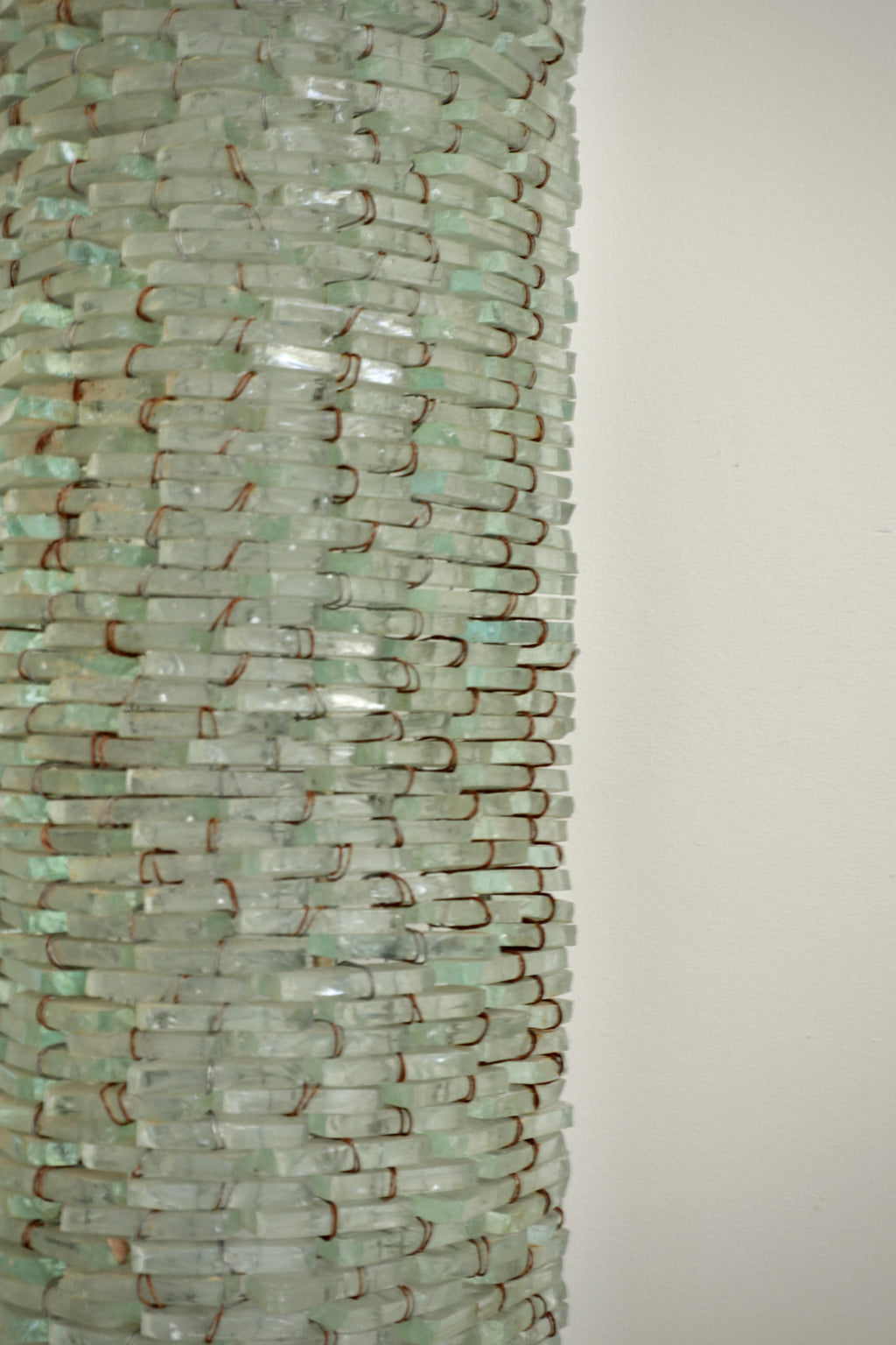 close-up detail of hand wired murano glass tiles forming sculptural mirror frame