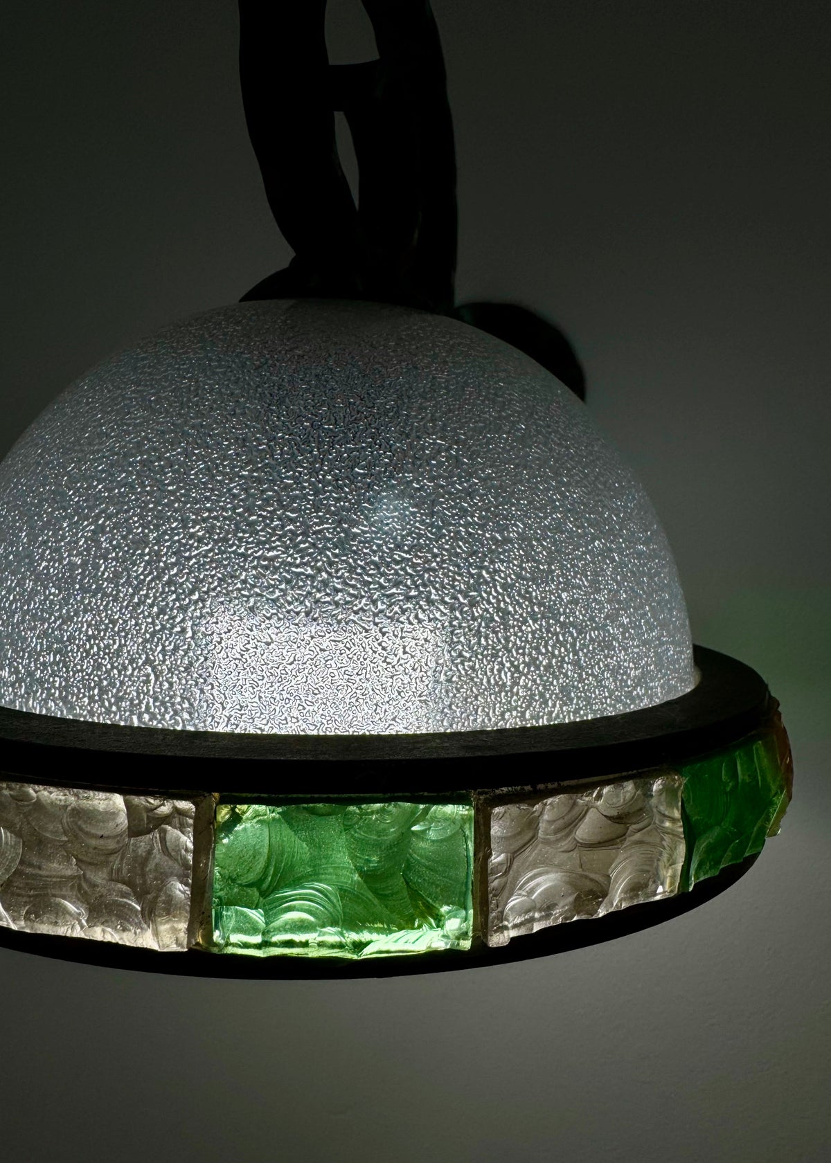 Detail of the textured green and clear glass band set into the brass rim of an Italian vintage wall sconce.