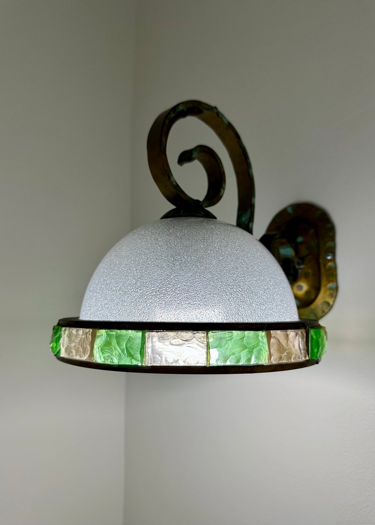 Side profile of a vintage Italian brass and glass wall appliqué showing the dome shade and projecting metal support.
