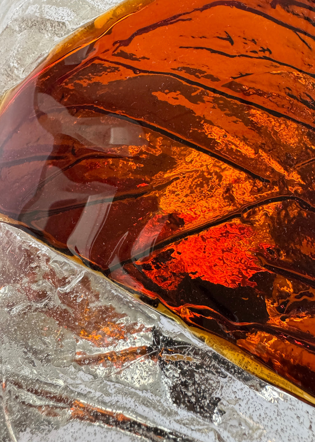 Close-up of amber-colored murano sconce with a textured surface