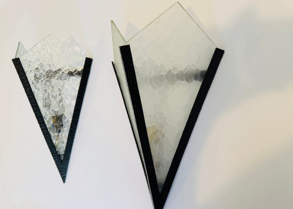 Two geometrically shaped sconces with black borders on a white background