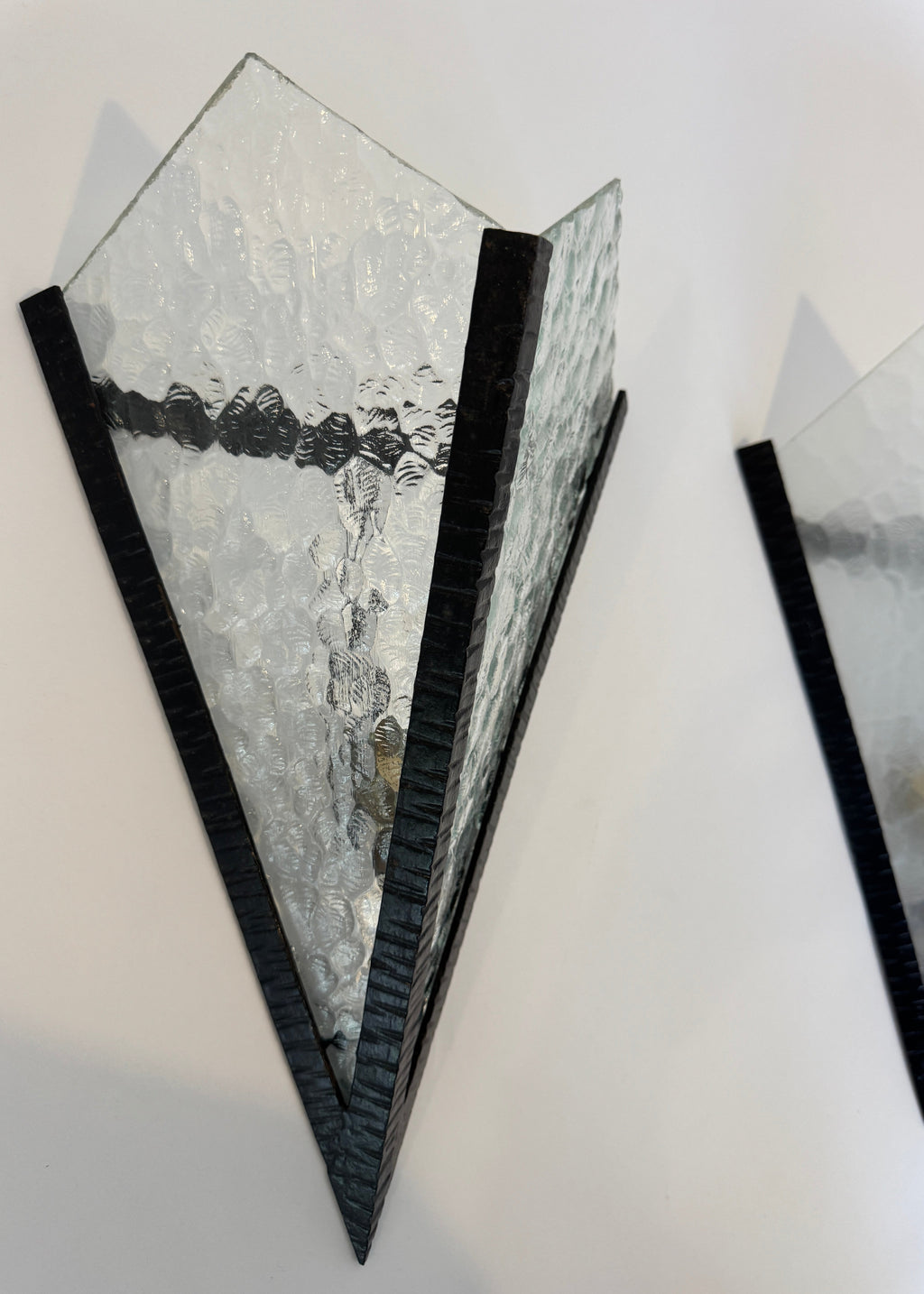 Pair of Italian textured glass wall sconces with blackened metal frames, 1970s architectural lighting