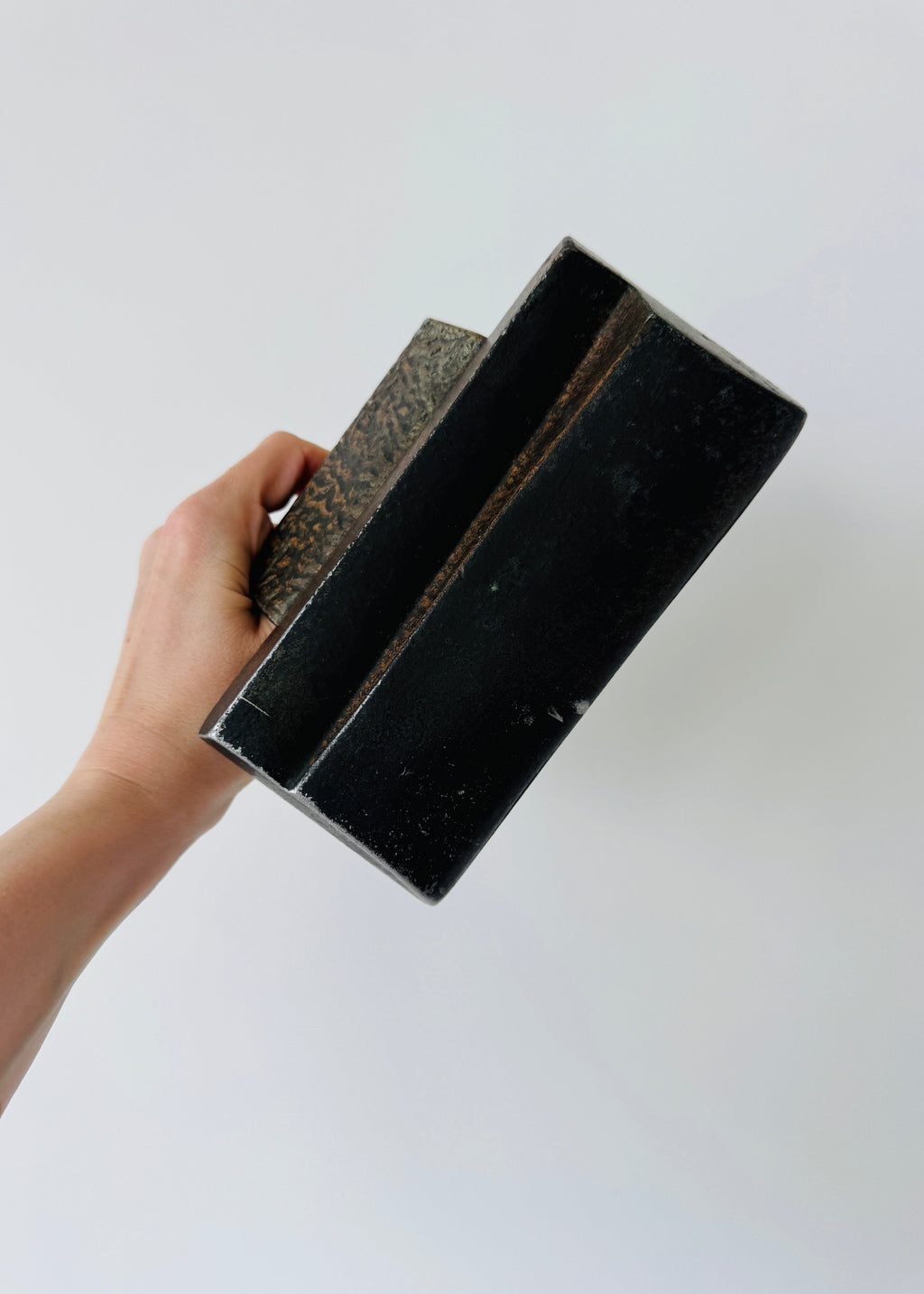 Vintage Brutalist sculptural door handle in dark patinated metal with angular folded grip and textured rectangular mounting plate.