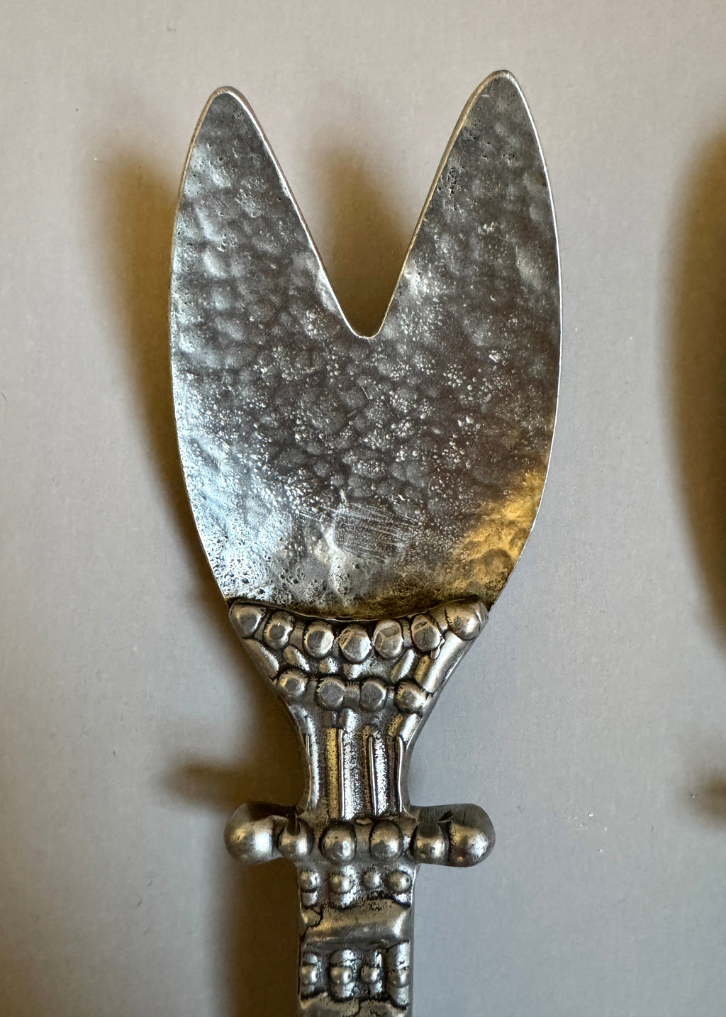 Vintage pewter salad serving set with decorative handles, including fork and spoon, styled on a neutral background