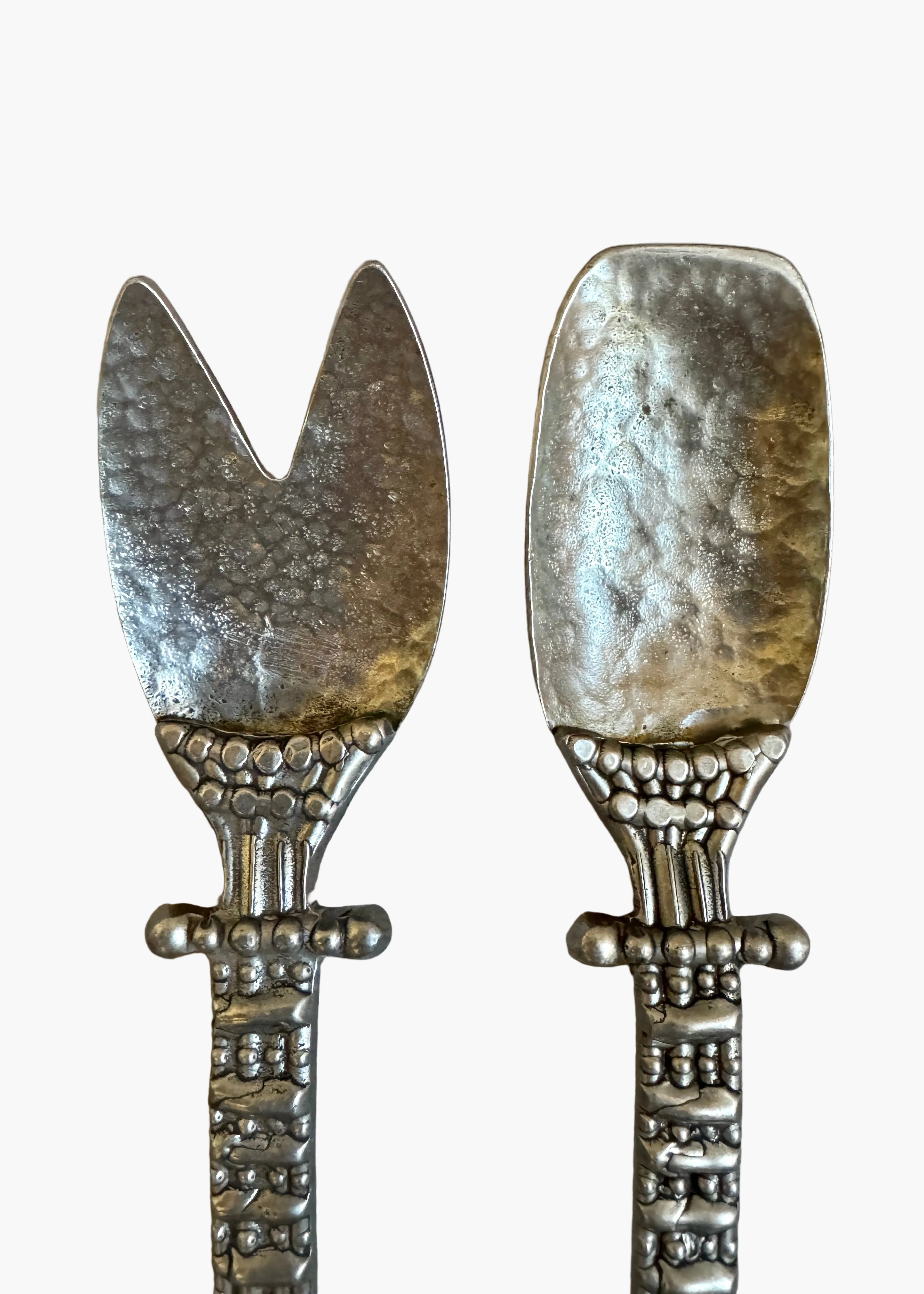 Vintage pewter salad serving set with decorative handles, including fork and spoon, styled on a neutral background