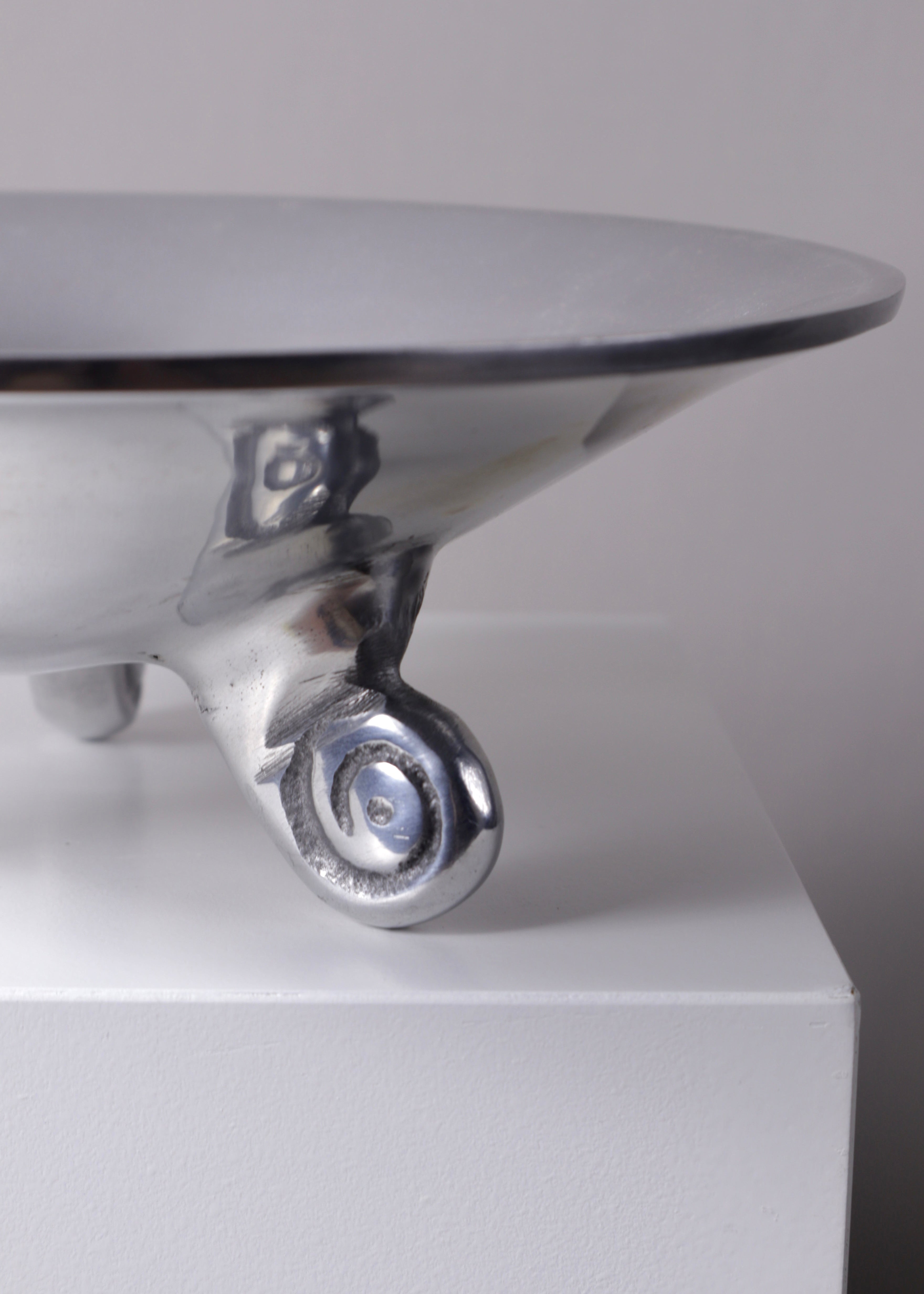 Vintage silver trinket bowl with sculptural scroll feet displayed on a white plinth