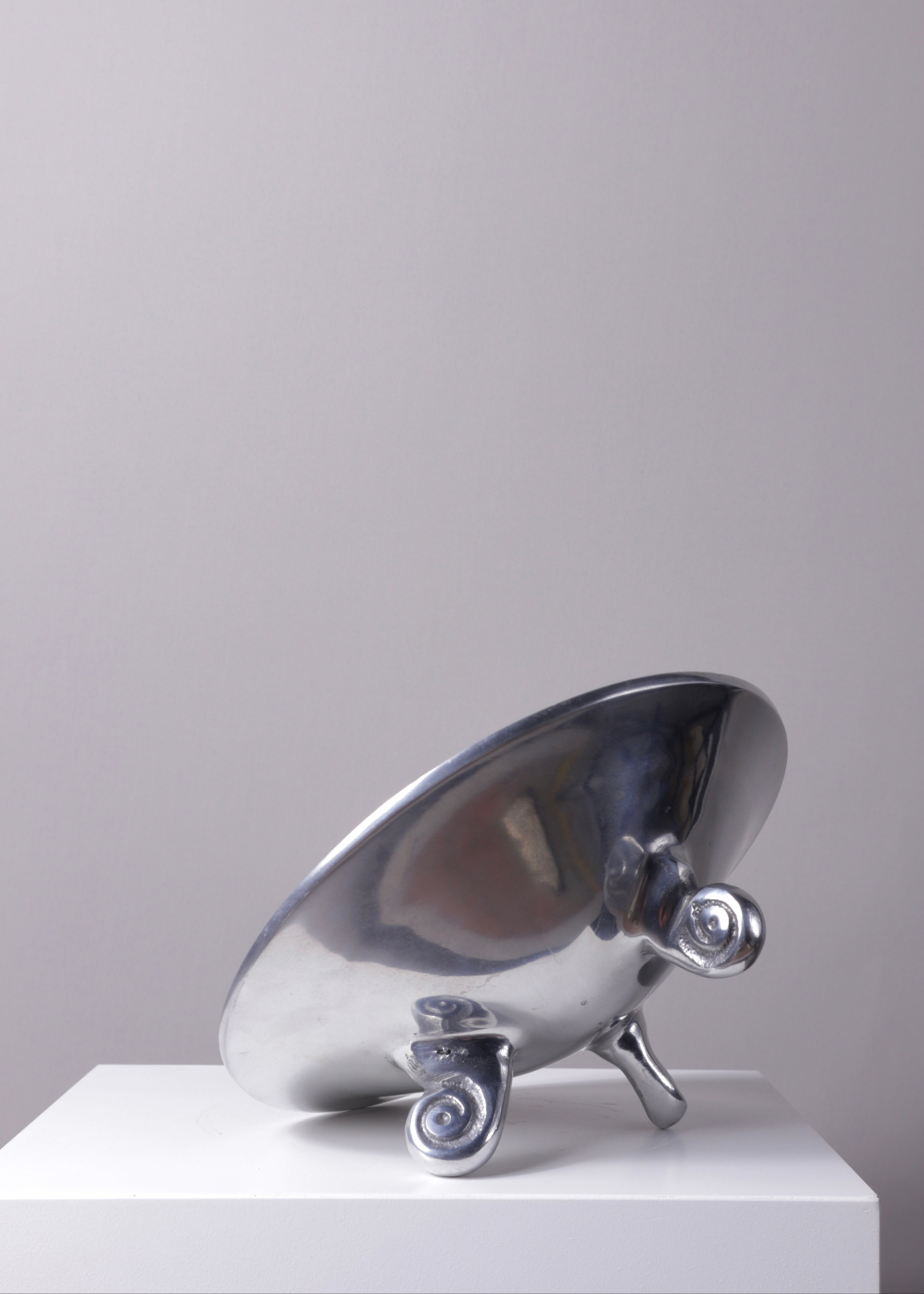 Vintage silver trinket bowl with sculptural scroll feet displayed on a white plinth