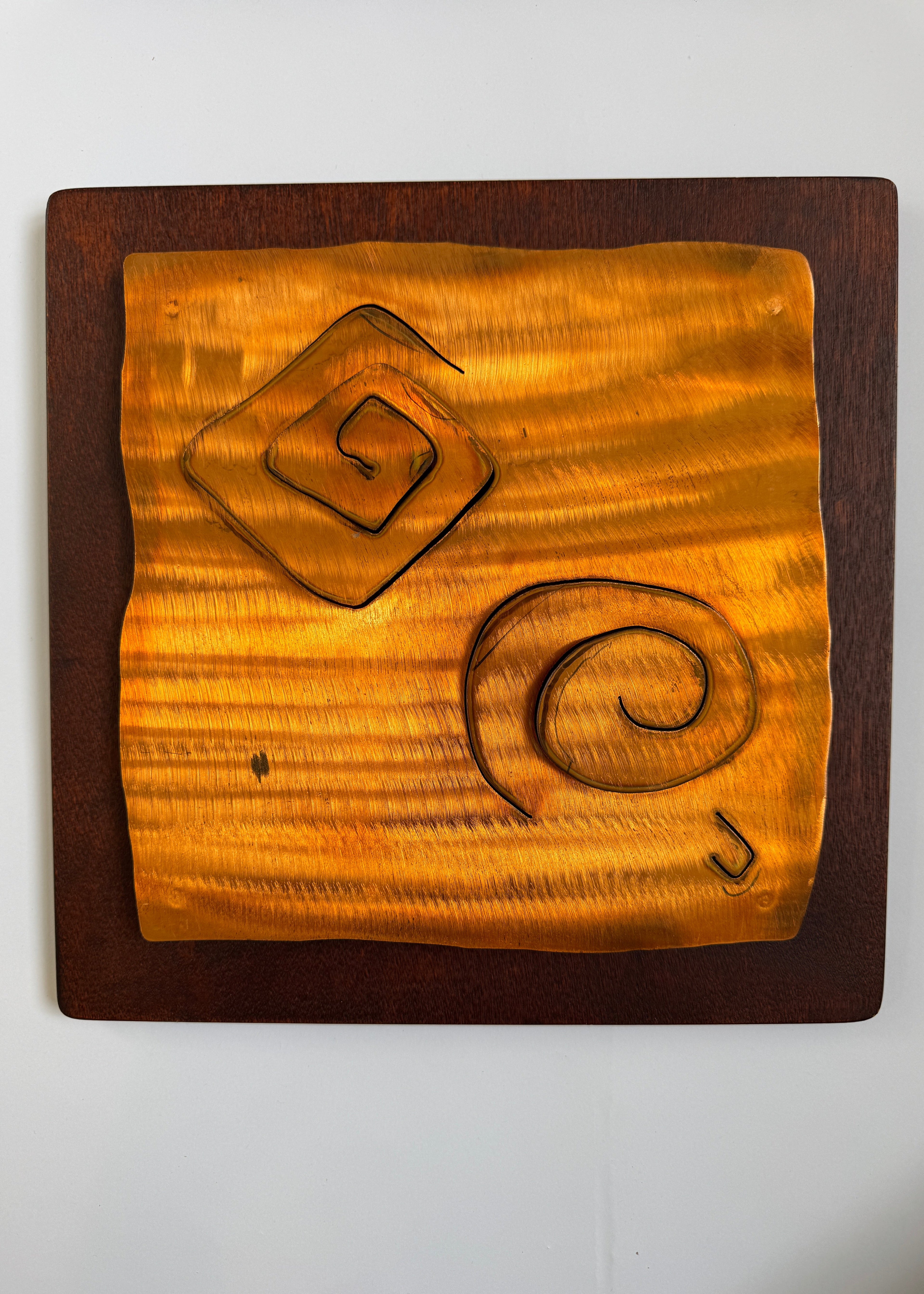 Wooden plaque with geometric carvings on a white background